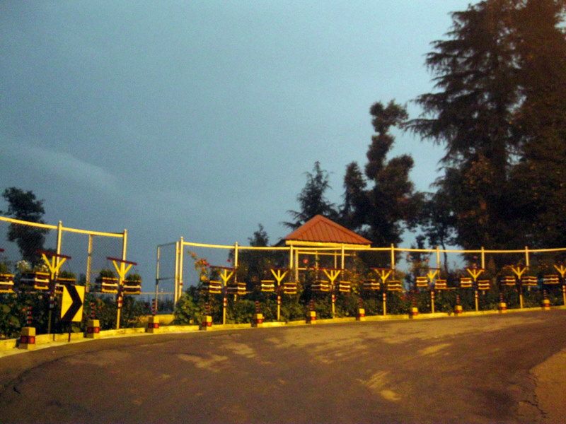 Mountain road curve with gazebo and deodars at twilight